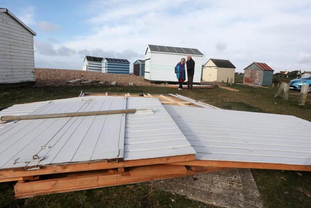 Beach hut owners David Flower, 84, and his wife Jacqueline Flower, 83, with their broken beach hut on Hayling Island seafront