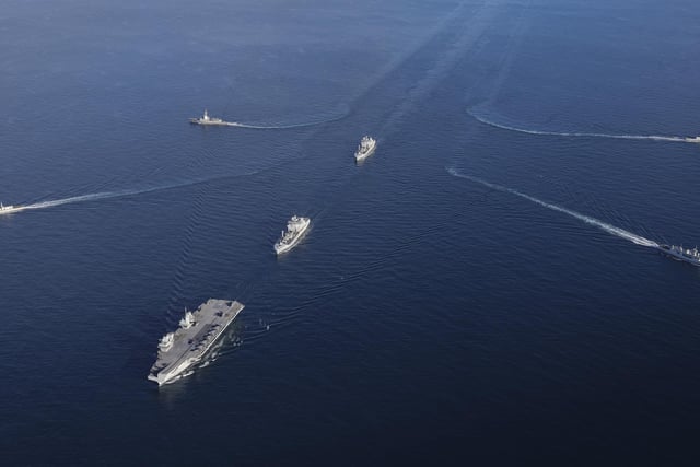 The UK Carrier Strike Group during Exercise Joint Warrior. Aerial imagery of the UKCSG Task Group taken from a Merlin Mk2 of 814 Naval Air Squadron.Viewed from the front - HMS Prince of Wales; Row 2 (L-R) – HMS Portland, RFA Tidesurge, HMCS Charlottetown; Row 3 (L-R) – SNS Cristόbal Colόn, RFA Tidespring, HMDS Niels Juel.