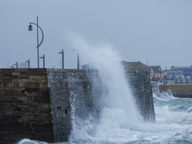 A moody sea crashed waves high onto footpaths as passer-by's did their best to get out the way