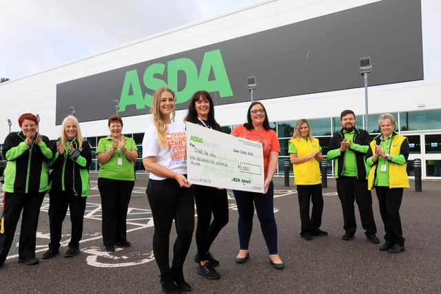 Asda's Katy Trapani, centre, with Becca White, fourth left, and Emma Cannon, fourth right, both of the charity, and Asda staff. Staff from Asda Havant present a cheque to Over The Wall children's charity on behalf of the Asda Foundation. Picture: Chris Moorhouse (jpns 290622-)