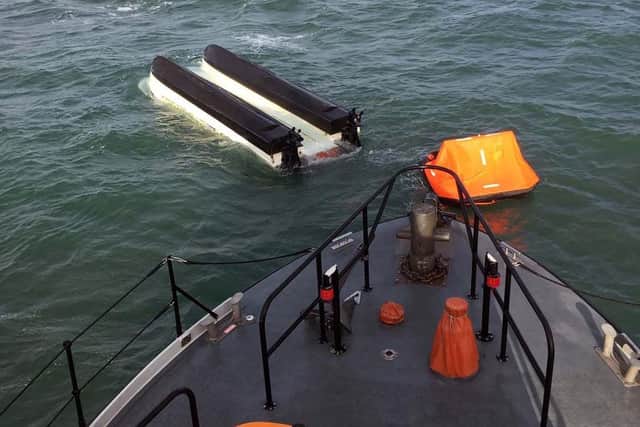 The capsized boat pictured following the rescue of its crew. Photo: Royal Navy.