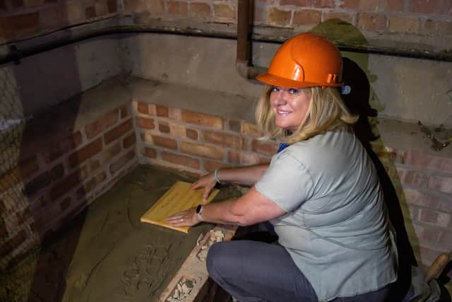 Caroline Wood (54), Head of School at Bedenham Primary School, places the plaque over the updated time capsule. Picture: Mike Cooter (120722)