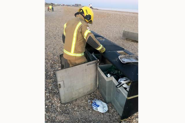 A firefighter removing a disposable barbecue from Hayling Island beach yesterday evening Monday, May 25.