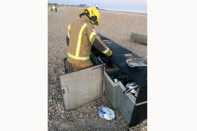 A firefighter removing a disposable barbecue from Hayling Island beach yesterday evening Monday, May 25.

