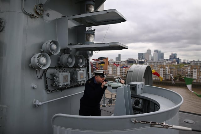 Navy photographer Petty Officer Ray Jones demonstrating the use of a compass on the bridge of HMS Illustrious. Photo by Dan Kitwood/Getty Images
