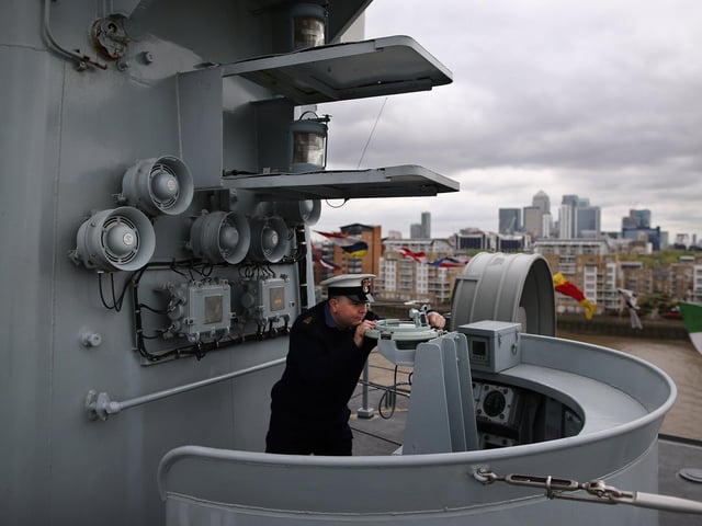 Navy photographer Petty Officer Ray Jones demonstrating the use of a compass on the bridge of HMS Illustrious. Photo by Dan Kitwood/Getty Images