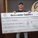 Christopher Welburn, 33, with his cheque for £35,500 after winning the minor three-card poker jackpot at Grosvenor Casino in Gunwharf Quays. Picture: Natalie Harman.
