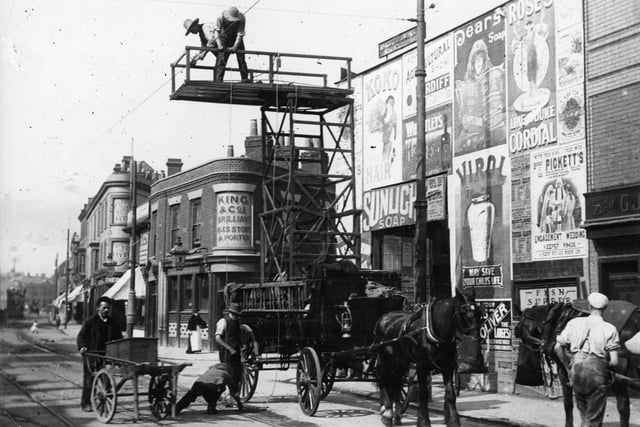 23rd February 1901:  Workmen erecting the overhead wires in Commercial Road for the electric tram from a tower wagon, in Portsmouth.  (Photo by F J Mortimer/Getty Images)