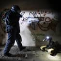 Pictured: An EOD Operator searches a building for an IED during a training exercise.