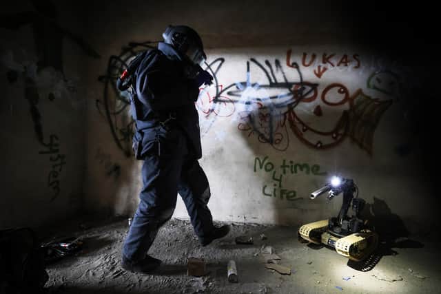 Pictured: An EOD Operator searches a building for an IED during a training exercise.