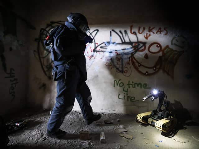 Pictured: An EOD Operator searches a building for an IED during a training exercise.
