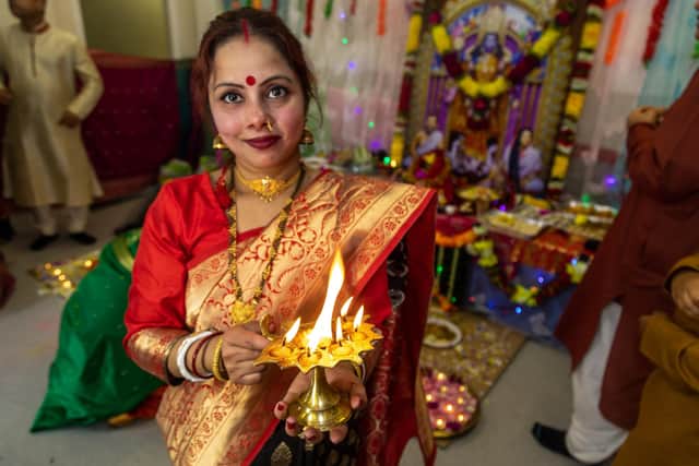 The auspicious aarati flame is offered around the room at the end of the celebrations. Picture: Mike Cooter (041121)