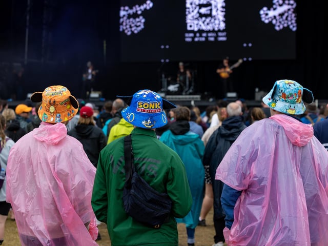 Watching the Tors on stage despite the downpour. Picture: Mike Cooter (240824)