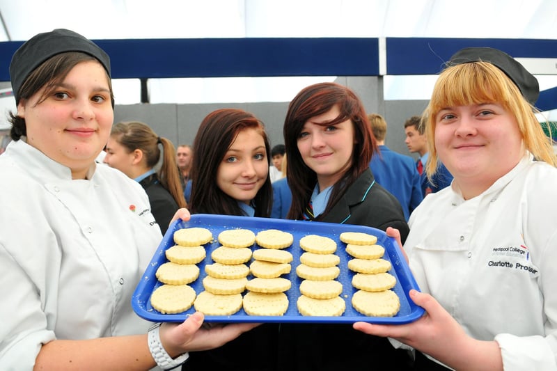 Hartlepool College of Further Education catering students Danielle Thomas (left) and Charlotte Prosser offer a cake to Dyke House Sports and Technology College pupils Jessica Payne and Ashlyn Pell (centre right) in 2013. Who can tell us more about this scene?