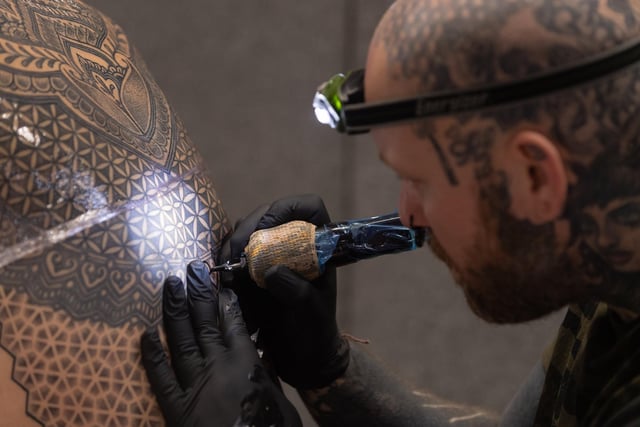 Pictured is: Jen Bradley tattoos Wayne Huggitt with an intricate pattern
Picture: Keith Woodland (010421-9)