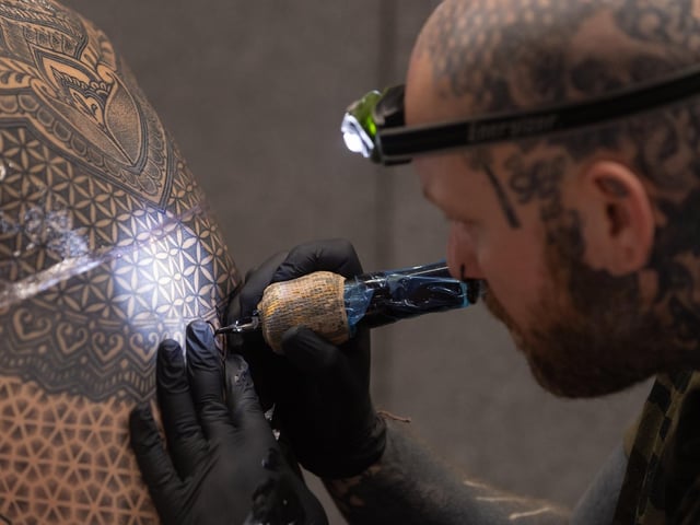 Pictured is: Jen Bradley tattoos Wayne Huggitt with an intricate pattern
Picture: Keith Woodland (010421-9)