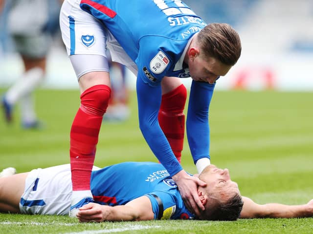 Ronan Curtis tends to Lee Brown following his hamstring injury against Burton