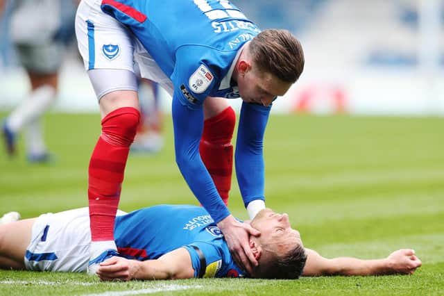 Ronan Curtis tends to Lee Brown following his hamstring injury against Burton