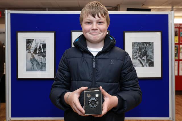Jack Shields, 14, with some of his work. He is holding a Box Brownie that he bought today to add to his camera collection. Wildlife photography exhibition at the Central Library, Portsmouth. The work is by pupils from The Harbour School
Picture: Chris Moorhouse (jpns 200521-01)