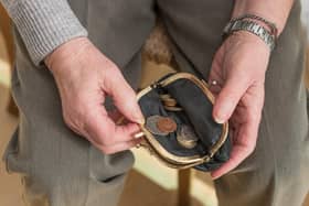 Hands of a pensioner checking loose change in an open purse