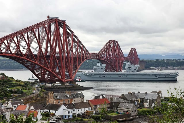 HMS Queen Elizabeth leaving Rosyth in Fife, Scotland, and sailing under the Forth bridge. She is due to return home to Portsmouth on July 30.