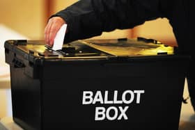 A voter places a ballot paper in the ballot box at a polling station Picture: PA