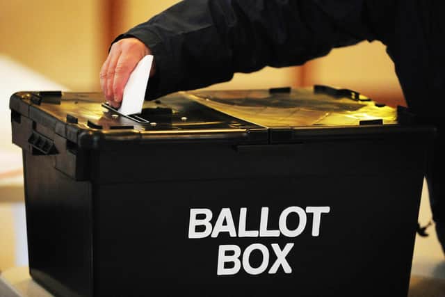 A voter places a ballot paper in the ballot box at a polling station Picture: PA