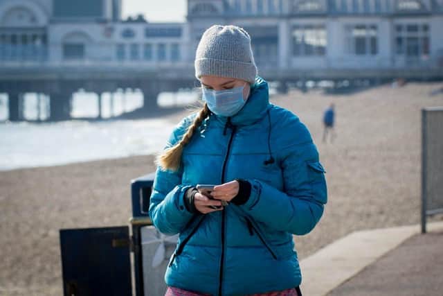 A woman wears a mask in Southsea while looking at her phone.
Picture: Habibur Rahman