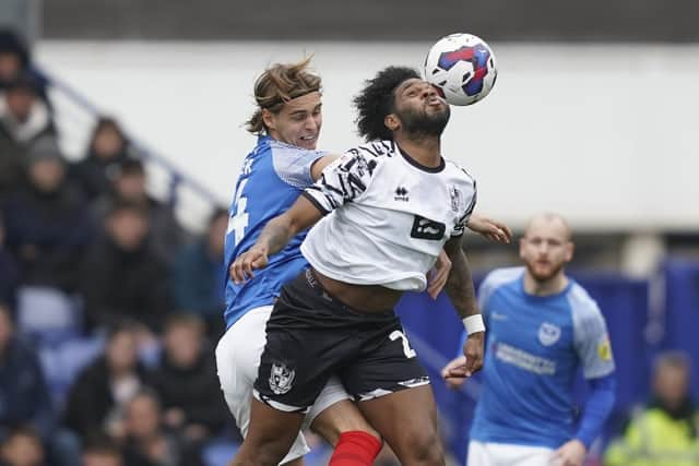 Ryley Towler tangles with ex-Pompey striker Ellis Harrison in Saturday's 2-2 draw with Port Vale. Picture: Jason Brown/ProSportsImages