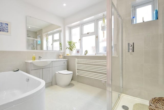 The bathroom is modern and spacious with a shower, bath and stylish vanity basin.