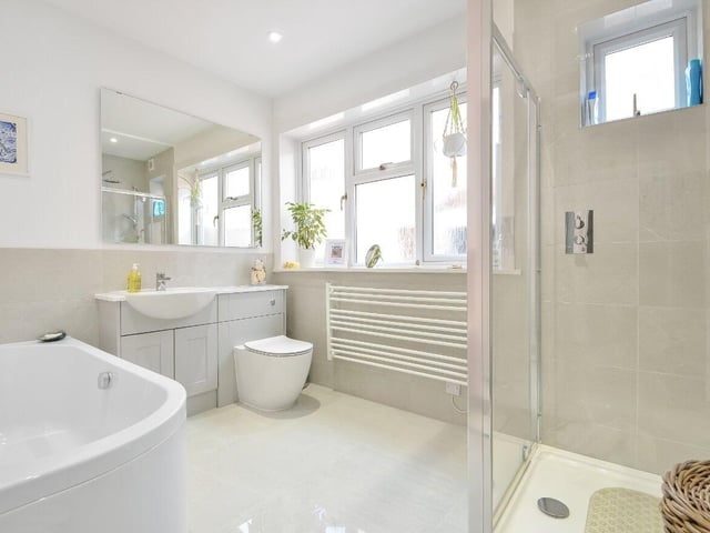 The bathroom is modern and spacious with a shower, bath and stylish vanity basin.