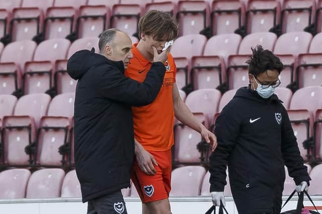 Pompey defender Sean Raggett is helped off the pitch following a clash of heads with Wigan forward Callum Lang. Picture: Daniel Chesterton/phcimages.com