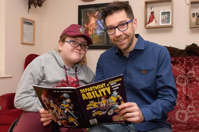 Emily and Dan White with a copy of his comic, Department of Ability.
Picture: Keith Woodland (300319-6)