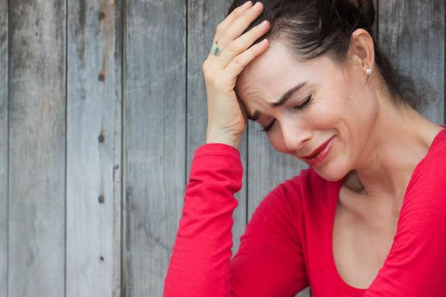 A very upset and lonely woman sitting down crying against a wall. Photo: Johan Larson - Fotolia