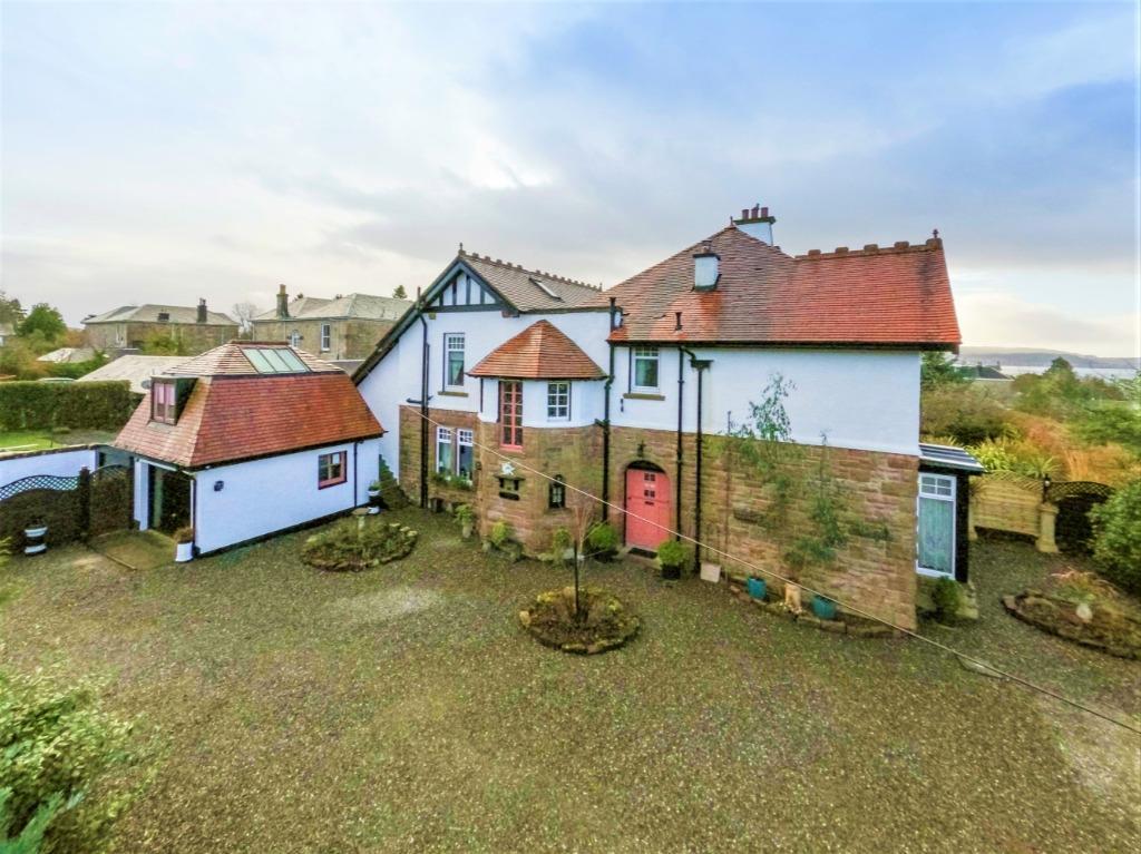 Front of property with gravelled driveway and parking area.