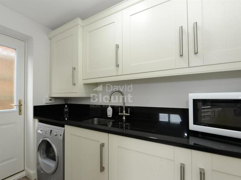 This utility room is sure to come in handy. As well as a sink and work surfaces, it includes a cupboard housing the gas central-heating boiler