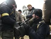 Members of the Ukrainian Territorial Defence Forces examine new armament, including NLAW anti-tank systems and other portable anti-tank grenade launchers, in Kyiv on March. Photo by GENYA SAVILOV/AFP via Getty Images