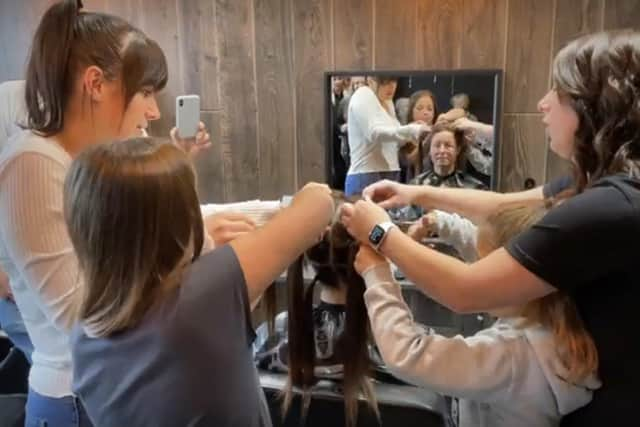 Merina's family having a go at shaving her hair