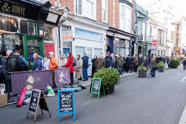 A group of people queuing outside Pie and Vinyl with tents.