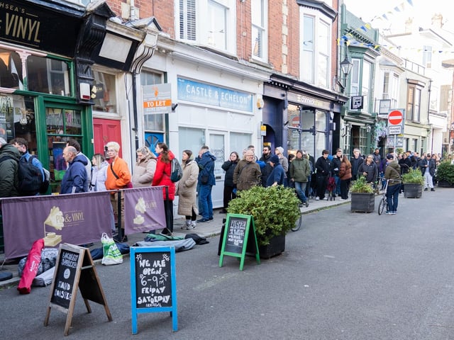 A group of people queuing outside Pie and Vinyl with tents.