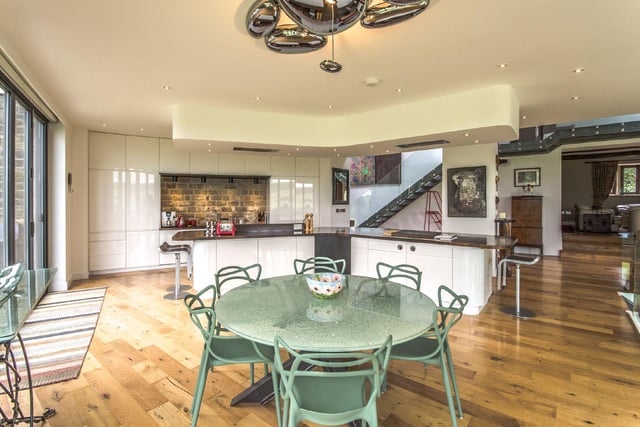 The bespoke kitchen boasts high gloss units, a built-in double cooker and grill, integrated appliances and a wooden breakfast bar, with a Teppanyaki station.