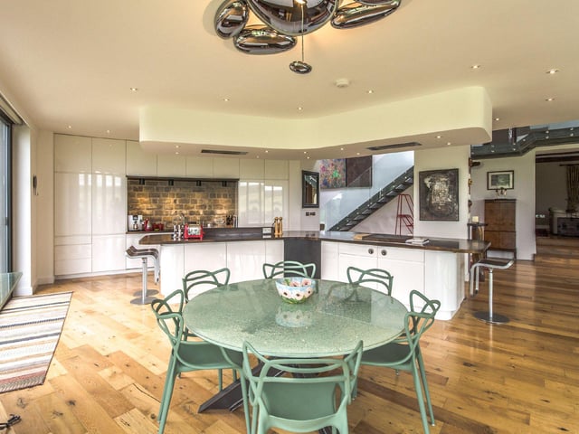 The bespoke kitchen boasts high gloss units, a built-in double cooker and grill, integrated appliances and a wooden breakfast bar, with a Teppanyaki station.