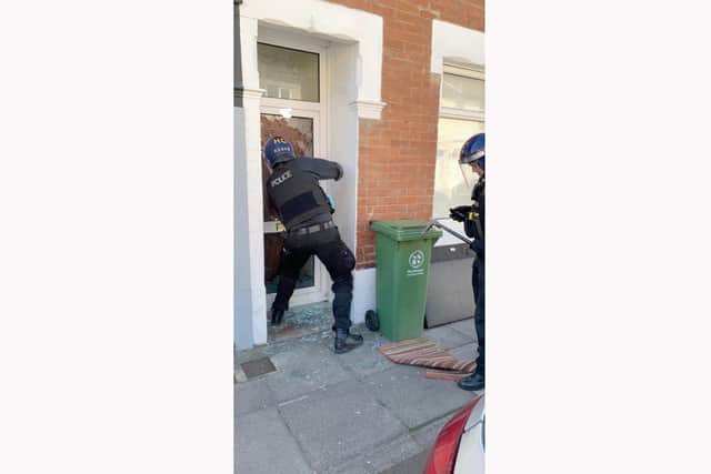Police officers look to gain entry to the property as part of a drugs raid.

Picture: @Pompeypolice