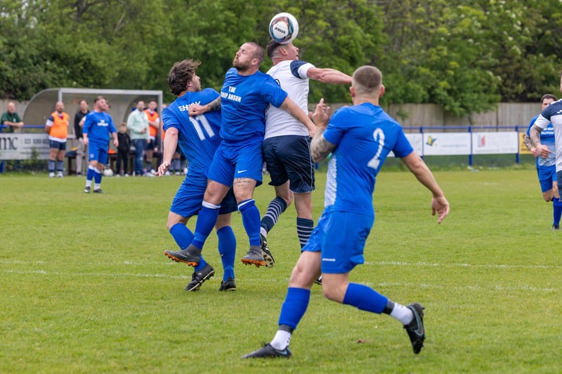 A member of Team Sherie rises above two challengers in the charity football match at Baffins Milton Rovers FC.