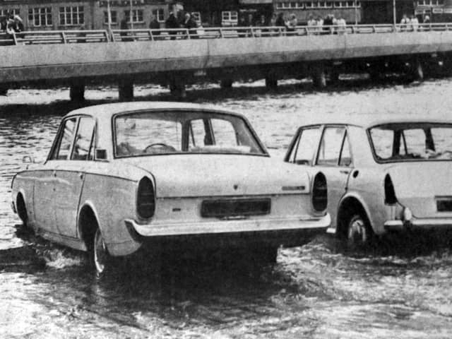 Two cars about to be overcome by the tide on the slipway at the  Hard in 1970. The new approach road from the Hard to the Harbour Station can be seen in the background.