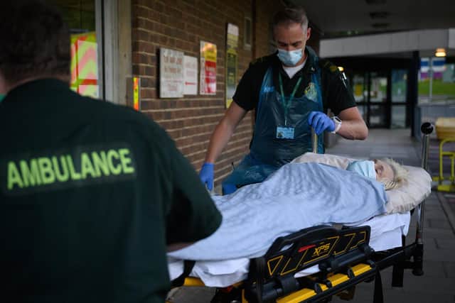 An ambulance crew wearing protective clothing transfer a patient, whose condition was described as not being related to Covid-19, from their ambulance to the Queen Alexandra hospital on May 05, 2020 near Portsmouth.  (Photo by Leon Neal - Pool/Getty Images)