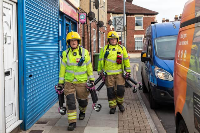 Fire Officers arrive with trolley jacks to remove cars from affected area. Picture: Mike Cooter (221021)