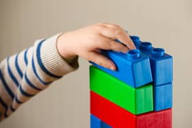 A preschool age child playing with plastic building blocks. Photo credit should read: Dominic Lipinski/PA Wire