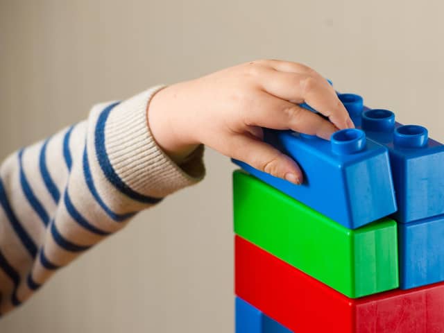 A preschool age child playing with plastic building blocks. Photo credit should read: Dominic Lipinski/PA Wire