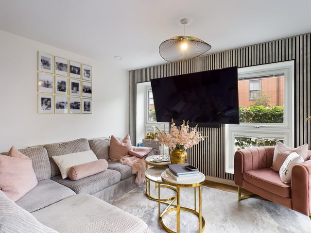 The living room has kitchen area at one end, with high gloss white units and fully integrated appliances alongside a dining area.